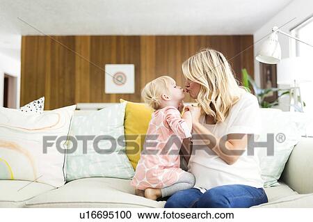 Woman kissing daughter (2-3) in living room View Large Photo Image Stock Image - Woman kissing daughter (2-3) in living room. Fotosearch