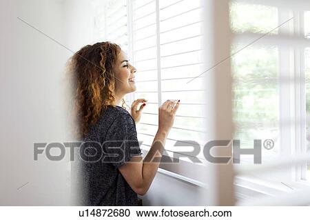 Woman looking through window View Large Photo Image Stock Image - Woman looking through window. Fotosearch