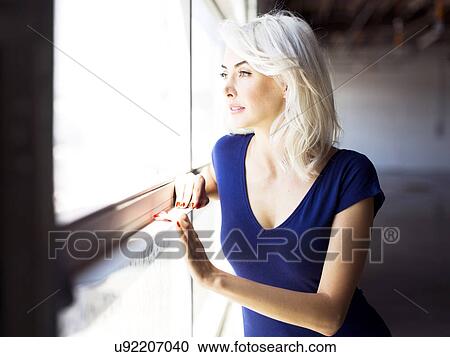 Woman looking through window View Large Photo Image Stock Image - Woman looking through window. Fotosearch