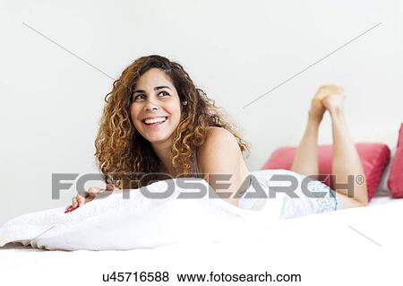 Woman lying on bed View Large Photo Image Stock Photo - Woman lying on bed. Fotosearch