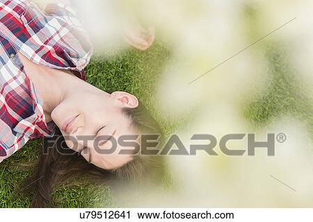 Woman lying on grass View Large Photo Image Stock Image - Woman lying on grass. Fotosearch