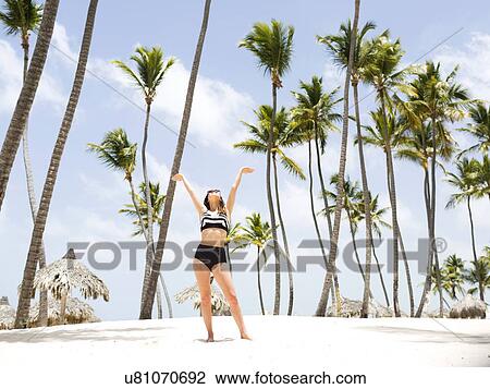 Woman on beach against palm trees View Large Photo Image Stock Image - Woman on beach against palm trees. Fotosearch