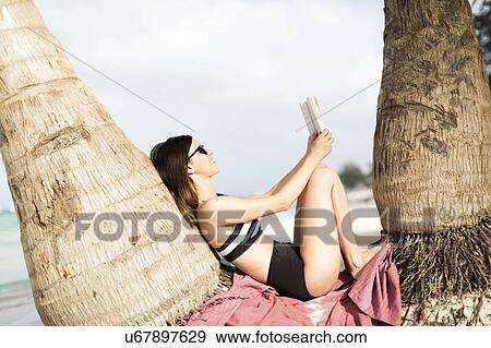 Woman relaxing by palm trees View Large Photo Image Stock Photo - Woman relaxing by palm trees. Fotosearch