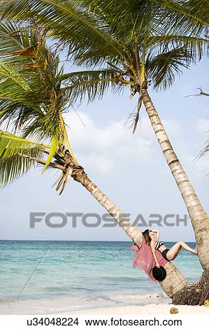 Picture - Woman relaxing on beach. Fotosearch