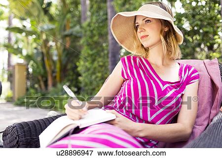 Woman sitting on chair View Large Photo Image Stock Photo - Woman sitting on chair. Fotosearch