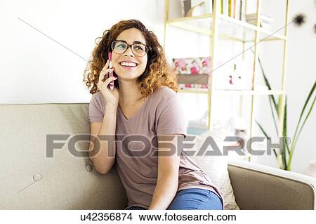 Woman sitting on sofa View Large Photo Image Picture - Woman sitting on sofa. Fotosearch