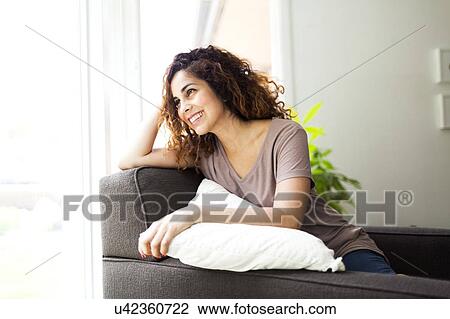 Woman sitting on sofa View Large Photo Image Stock Image - Woman sitting on sofa. Fotosearch