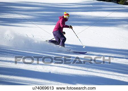 Stock Image - Woman skiing downhill. Fotosearch