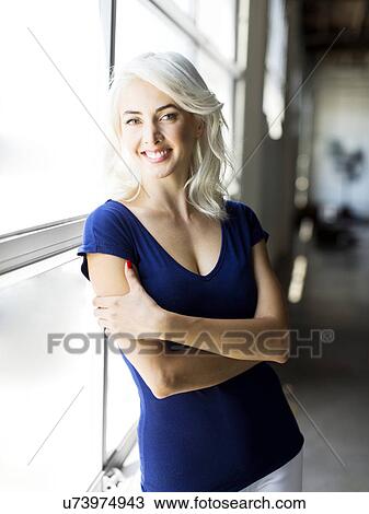 Woman standing by window View Large Photo Image Stock Image - Woman standing by window. Fotosearch
