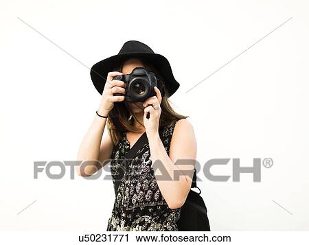 Stock Image - Woman taking photos during vacations. Fotosearch