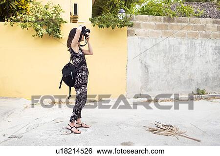 Stock Photograph - Woman taking photos during vacations. Fotosearch