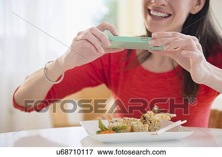 Stock Photo - Woman taking picture of meal with Smartphone. Fotosearch