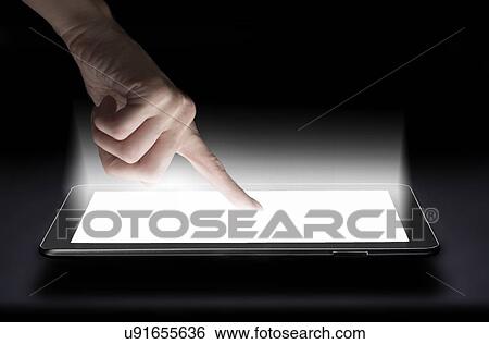 Stock Photograph - Woman touching digital tablet in studio. Fotosearch