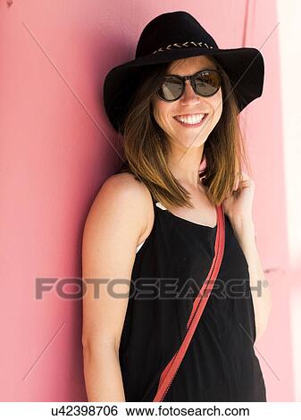 Stock Photograph - Woman under pink wall. Fotosearch