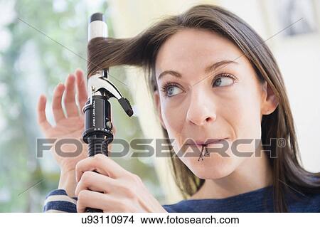 Woman using curler to do her hair View Large Photo Image Picture - Woman using curler to do her hair. Fotosearch