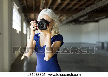 Woman using digital camera View Large Photo Image Stock Photography - Woman using digital camera. Fotosearch