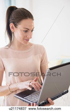 Woman using laptop at home View Large Photo Image Stock Photo - Woman using laptop at home. Fotosearch