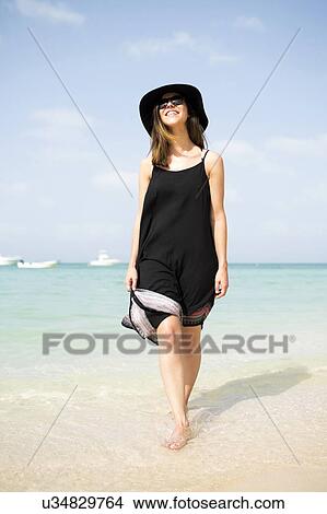 Picture - Woman walking on beach. Fotosearch