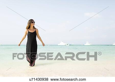 Stock Photo - Woman walking on beach. Fotosearch