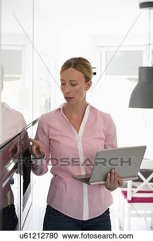Woman with laptop in kitchen View Large Photo Image Stock Image - Woman with laptop in kitchen. Fotosearch