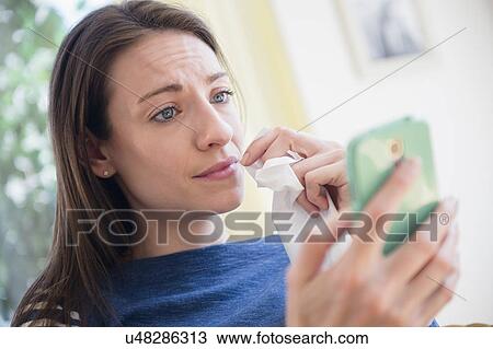 Woman with tissue watching Smartphone View Large Photo Image Stock Image - Woman with tissue watching Smartphone. Fotosearch