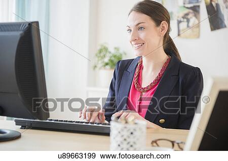 Stock Photo - Woman working in office. Fotosearch