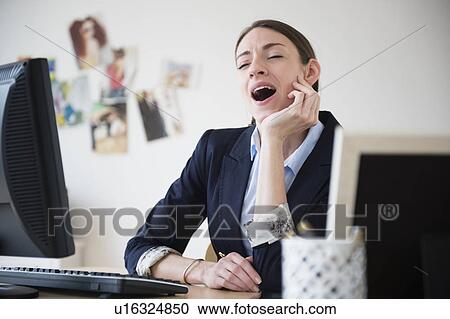Woman yawning in office View Large Photo Image Stock Image - Woman yawning in office. Fotosearch