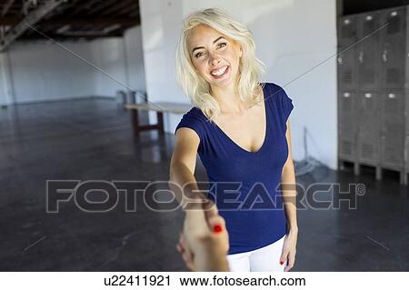 Stock Image - Women shaking hands in warehouse. Fotosearch