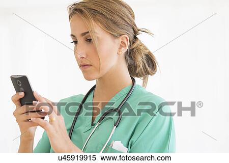 Young female doctor using smart phone View Large Photo Image Stock Photography - Young female doctor using smart phone. Fotosearch