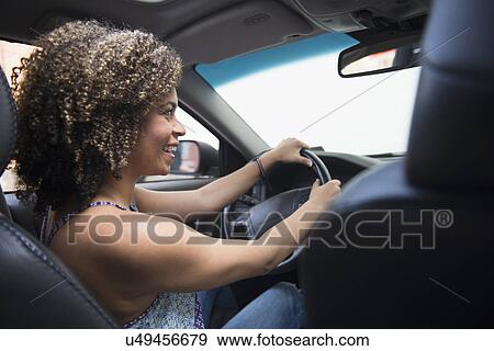 Stock Photo - Young woman driving car. Fotosearch