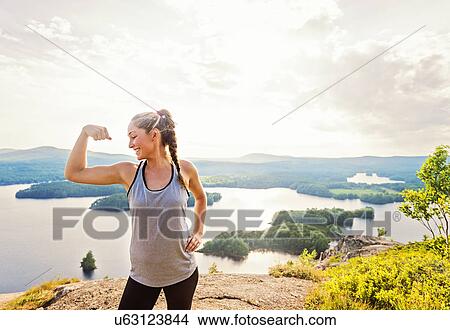Picture - Young woman flexing muscles. Fotosearch