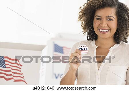 Young woman holding voting badge and smiling View Large Photo Image Stock Photograph - Young woman holding voting badge and smiling. Fotosearch