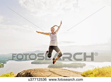 Young woman jumping over mountain top View Large Photo Image Stock Photograph - Young woman jumping over mountain top. Fotosearch