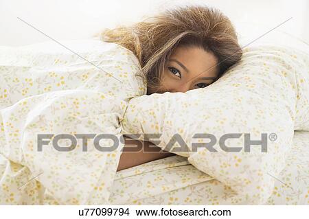 Picture - Young woman lying in bed. Fotosearch