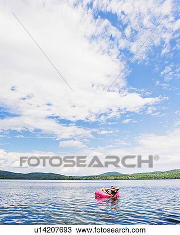 Young woman relaxing on lake in pool raft View Large Photo Image Stock Image - Young woman relaxing on lake in pool raft. Fotosearch