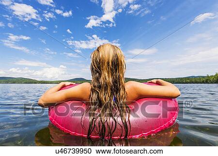 Young woman relaxing on lake in pool raft View Large Photo Image Stock Image - Young woman relaxing on lake in pool raft. Fotosearch