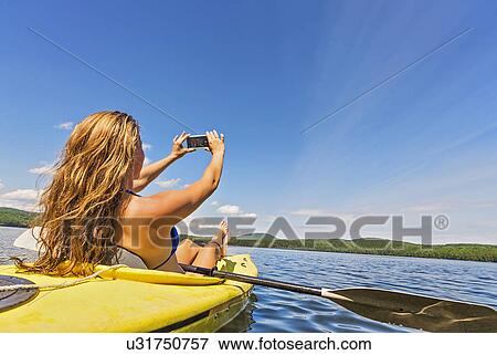 Young woman taking selfie in kayak on lake View Large Photo Image Stock Photo - Young woman taking selfie in kayak on lake. Fotosearch