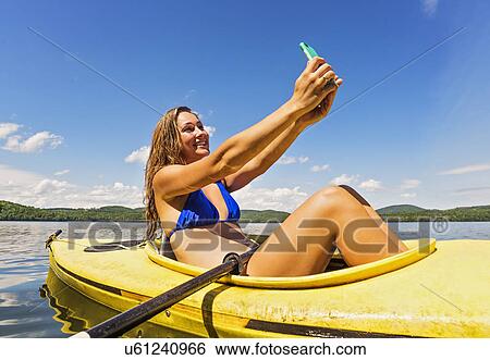 Young woman taking selfie in kayak on lake View Large Photo Image Stock Photograph - Young woman taking selfie in kayak on lake. Fotosearch