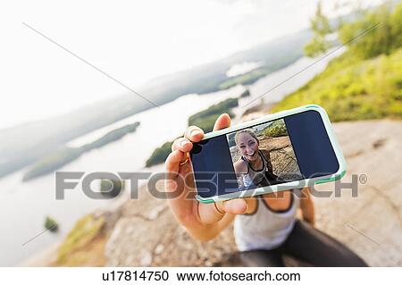 Young woman taking selfie on Smartphone View Large Photo Image Stock Image - Young woman taking selfie on Smartphone. Fotosearch