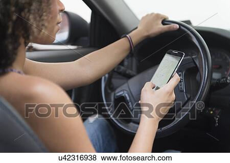 Young woman texting while driving car View Large Photo Image Stock Photo - Young woman texting while driving car. Fotosearch