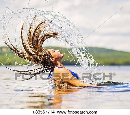 Young woman tossing hair back in lake View Large Photo Image Picture - Young woman tossing hair back in lake. Fotosearch