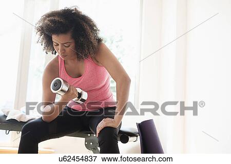 Young woman training with dumbbells View Large Photo Image Stock Photo - Young woman training with dumbbells. Fotosearch