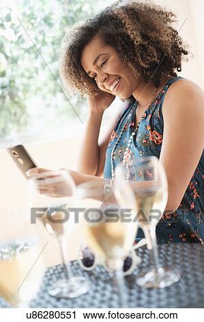 Young woman using smart phone at restaurant View Large Photo Image Stock Image - Young woman using smart phone at restaurant. Fotosearch