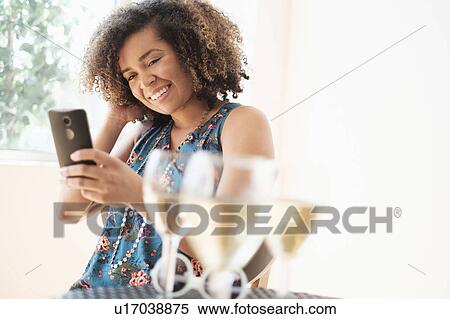 Young woman using smart phone at restaurant View Large Photo Image Stock Photography - Young woman using smart phone at restaurant. Fotosearch