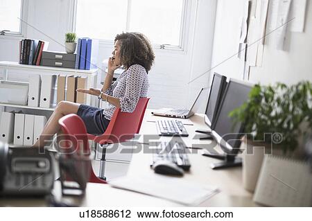Young woman working at office View Large Photo Image Stock Image - Young woman working at office. Fotosearch