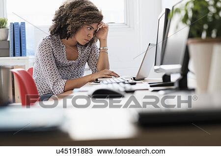 Young woman working at office View Large Photo Image Stock Image - Young woman working at office. Fotosearch