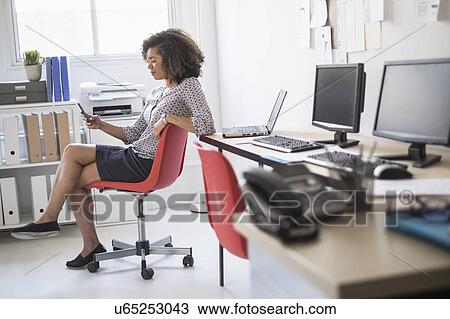 Young woman working at office View Large Photo Image Stock Image - Young woman working at office. Fotosearch
