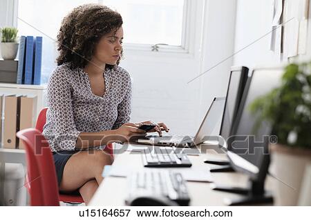 Young woman working at office View Large Photo Image Stock Photo - Young woman working at office. Fotosearch