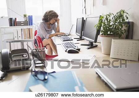 Young woman working at office View Large Photo Image Stock Photo - Young woman working at office. Fotosearch