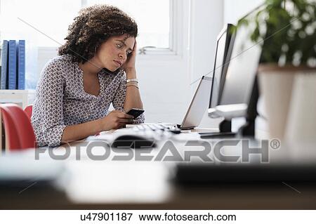 Young woman working at office View Large Photo Image Stock Photo - Young woman working at office. Fotosearch